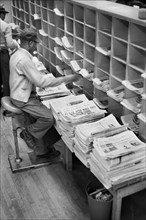 Worker sorting newspapers at Post Office, New York City, May 1957