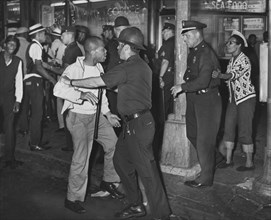 Policemen confront group of People after night of rioting due to fatal shooting of Teen James Powell by Police Officer Lt. Thomas Gilligan, Fulton St. and Nostrand Ave.,