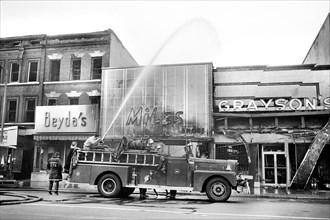 firefighters spraying water on shops that were burned during Riots that followed the Assassination of Martin Luther King, Jr., April 8