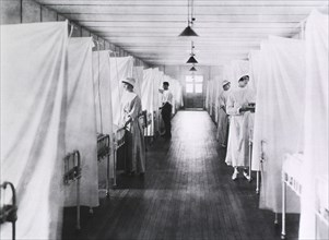 Nurses and Orderlies standing at foot of Beds separated by Sheets, Influenza Ward, 1918