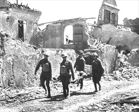 Four Soldiers carrying Wounded Soldier on Stretcher past Bombed-out Building, Vaux, 1918