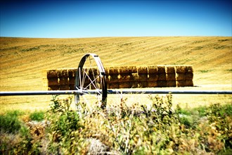 Agricultural Sprinkler and Hay Bales in Vast Field ,,
