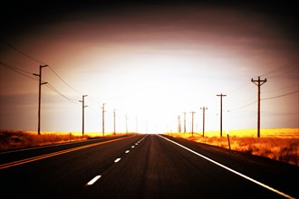 Empty Rural Highway, lined by Utility Poles,