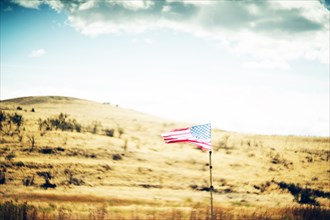 American Flag on Fence Post in Rolling Golden Landscape ,,