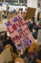 Protester holding Sign "We Will Love and Protect Each Other", Protest against Muslim Travel Ban,