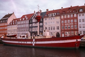 Boat on Nyhavn Canal with Quaint Buildings in Background at Sunset, Copenhagen,