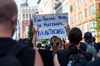 Crowd of Protesters with Signs, "End Racial Bias in Maternal Healthcare",
