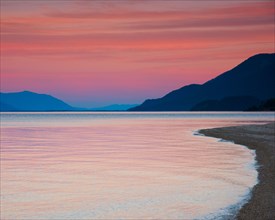 Shoreline with Mountains in Background at Sunset,,