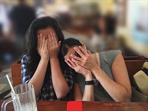Mother and Daughter hiding their Faces,,