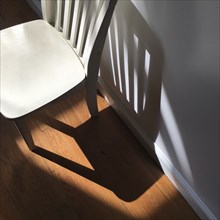 High Angle View of Child's Chair against Wall with Shadows,,