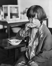 Drought Victim eating Cookies with Currants furnished by American Red Cross, Duncan Consolidated School