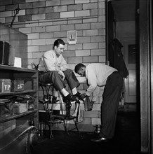 Greyhound Driver getting his Shoes shined by a Porter at the Garage, Pittsburgh