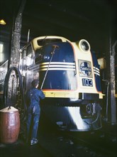 Worker washing a 54-hundred Horse Power Diesel Freight Locomotive in the Roundhouse, Atchison