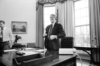 U.S. President Jimmy Carter standing behind his desk in the Oval Office of the White House, Washington