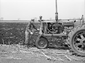 Farmer cranking Tractor while planting Corn, Listing method