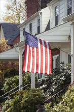 American flag hanging in front of Suburban House,