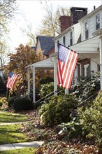American flags hanging in front of Suburban Houses,