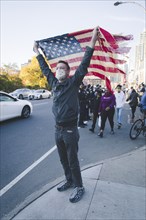 Man holding up American Flag during Celebration of President-Elect Joe Biden, Brooklyn