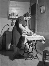 Mrs. Gaynor doing her ironing on her Farm