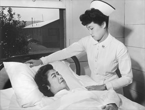 Nurse Aiko Hamaguchi adjusting Pillow for patient Toyoko Ioki