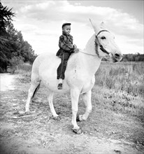 Boyd Jones riding one of his Father's Mules on their Farm