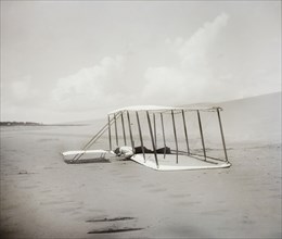 Wilbur Wright in prone position on glider just after landing