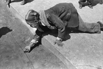 Young Boy playing Marbles