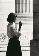 Woman wearing Blouse and Long Skirt smoking a Cigarette outside New York Public Library