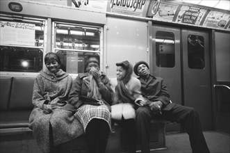 Four young adults sharing Laugh on Subway