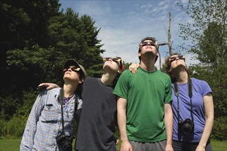 Small Group of People wearing Eclipse Glasses while viewing Partial Solar Eclipse