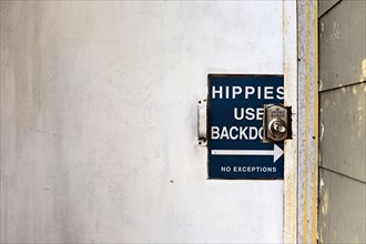 Sign on Door "Hippies Use Backdoor"