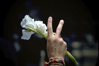 Protester giving Peace Sign while holding Flower