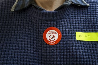Man with COVID-19 Vaccination Sticker on Sweater