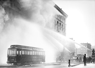 Fireman spraying water on burning building