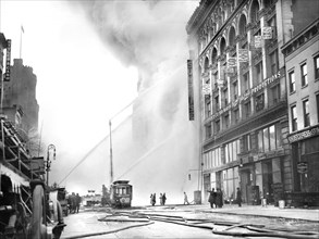 Fireman spraying water on burning building