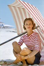 Casual Woman and Beach Umbrella with Red Stripes