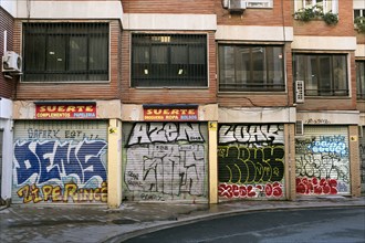 Row of Stores with Graffiti on Security Gates