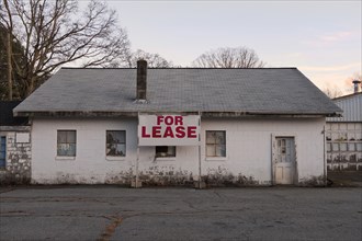 Dilapidated Cinder Block Building with For Lease Sign