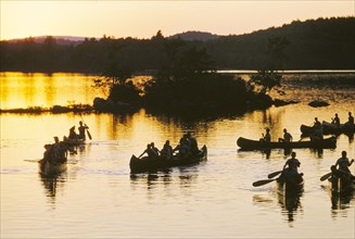 Silhouette of boys in Canoe Boats at Sunset