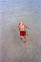 High Angle View of Young Boy floating on his back in Water