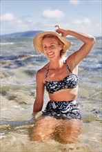Woman kneeling in Water at Beach
