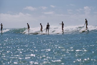 Silhouette of Surfers riding a Wave