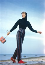 Fashionable Young Adult Woman in Striped Slacks and Hooded Top
