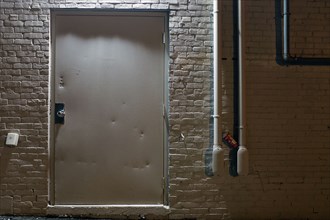 White Metal Door and White Brick Wall Exterior at Night