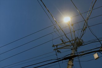 Low Angle View of illuminated Street Light and Utility Wires at Dusk