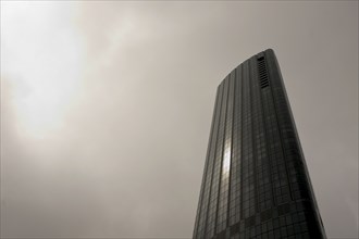 Low Angle View of Modern Skyscraper against Cloudy Sky