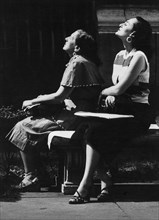Two Women sitting with their Heads tilted towards Sun