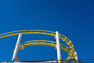 Low Angle View of Yellow Roller Coaster against Blue Sky