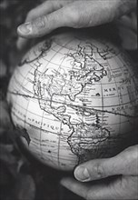 Two hands holding vintage globe of earth
