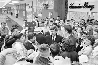 U.S. Senator John F. Kennedy with crowd of people at shopping mall while campaigning for U.S. President